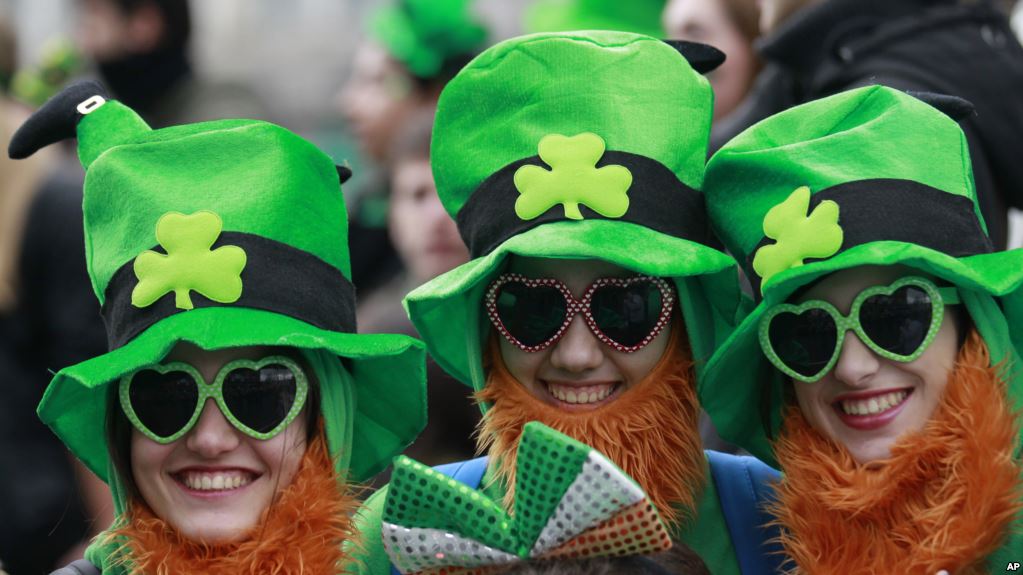 FILE - People dress in the emerald green to honour Ireland's Saint Partick, as they enjoy the atmosphere during the St Patrick's day parade in Dublin, Ireland, March, 17, 2014. (AP Photo/Peter Morrison)