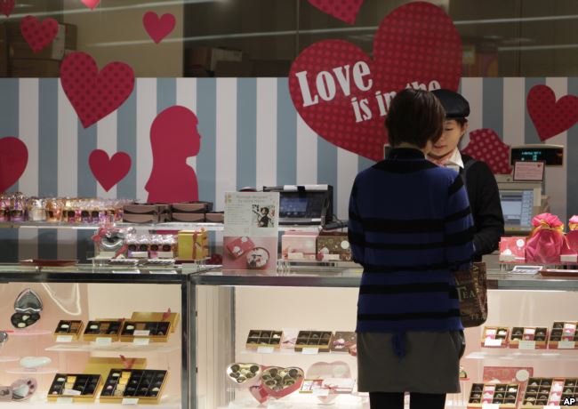 A woman buys Valentine's Day chocolates at a store in Tokyo Tuesday, Feb. 14, 2012.