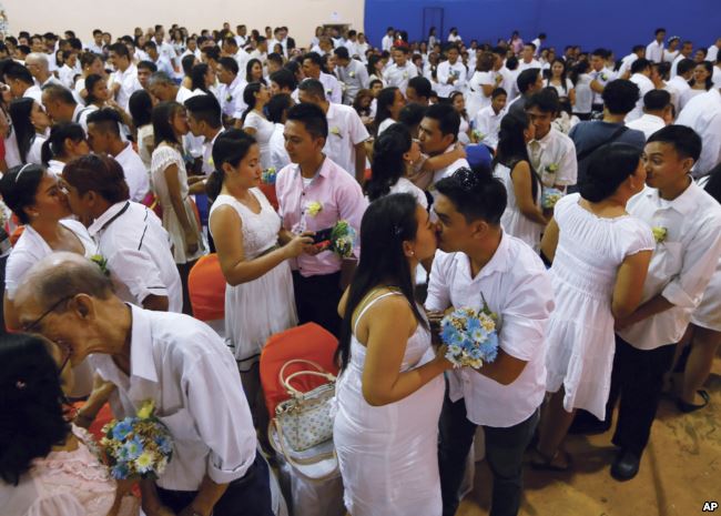 Filipino couples kiss during a mass wedding ahead of Sunday's Valentine's Day celebration in Manila, Philippines, Feb. 12, 2016 (AP Photo/Bullit Marquez)