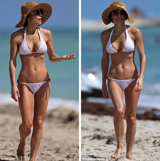 Refreshing: The reality show star enjoyed taking a dip in the sea but kept her hat and shades on for extra protection 