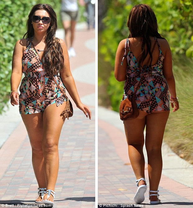 Playful on the promenade: The reality star lapped up the sunshine as she made her way to the beach in her printed playsuit 