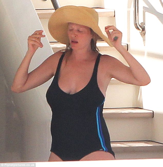 Hat's nice!: Uma shielded her face from the sun's rays with a floppy beige hat