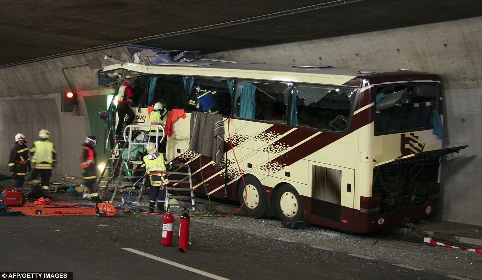 Devastated: Rescuers next to the wreckage of the bus which crashed into the tunnel wall