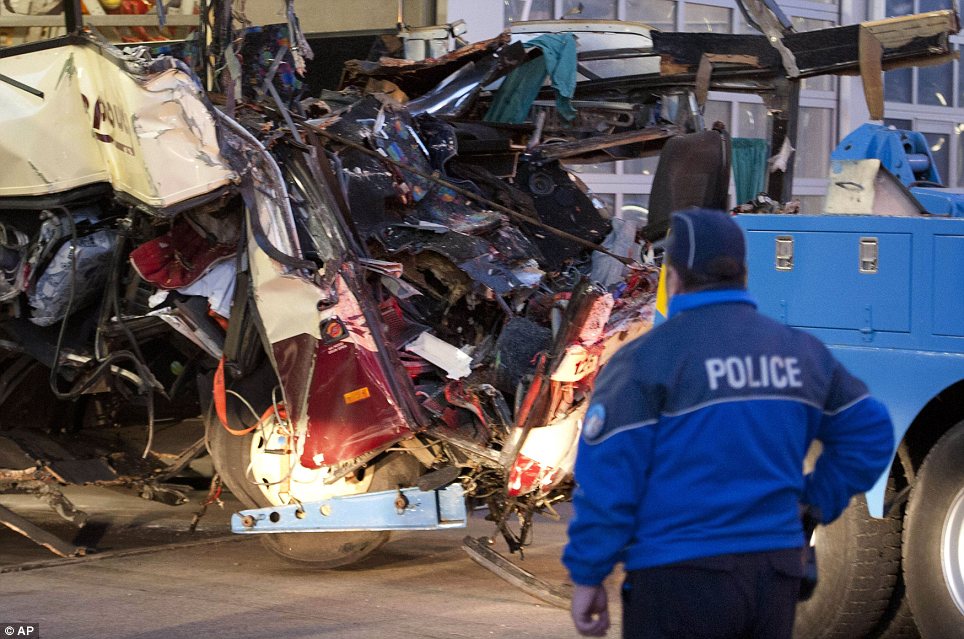 Wreckage: A police officer looks at the mangled remains of the bus
