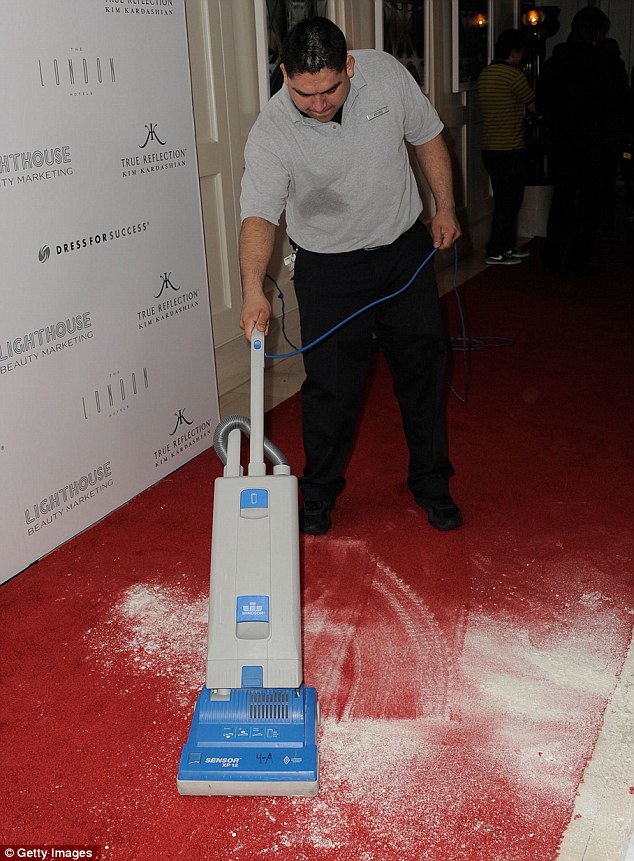Cleaning up the mess: A hotel worker was seen vacuuming up the flour as the red-carpet cleared 