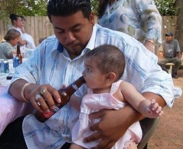 Get 'em started young: This little girl is having her first taste of alcohol about 17-and-a-half years too early