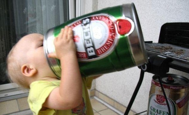 Hitting the bottle: This youngster is given an early taste of manhood as he appears to knock back a can of beer