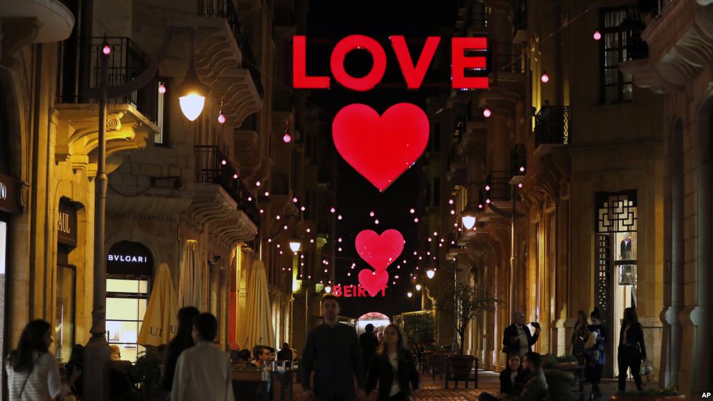 Lebanese citizens walk by Valentine's Day decorations, in downtown Beirut, Lebanon, Friday, Feb. 9, 2018. 