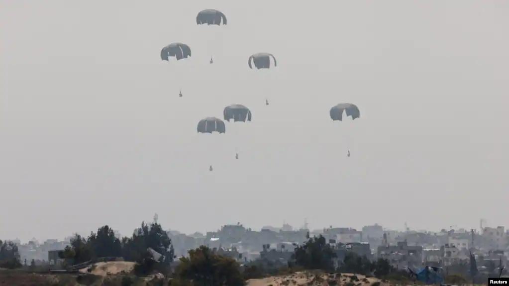 2024年3月28日,在以色列与哈马斯之间持续不断的冲突中,人道主义援助物资从飞机空投下来后落向加沙地带。(路透社照片)