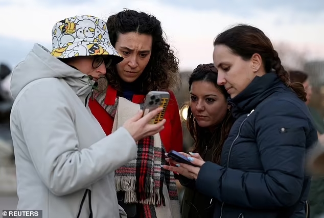A group of people outside Buckingham Palace reacting to Kate Middleton's cancer diagnosis 