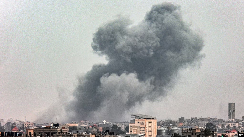 从加沙地带南部城市拉法看到的在以色列轰击加沙地带中部城市汗尤尼斯时从汗尤尼斯冒起的浓烟。(2024年3月29日)