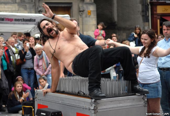Magician Timothy Terror gets off a bed of nails as he performs on the first day of the Edinburgh Fringe Festival, Aug 2010. (AP /Scott Campbell)